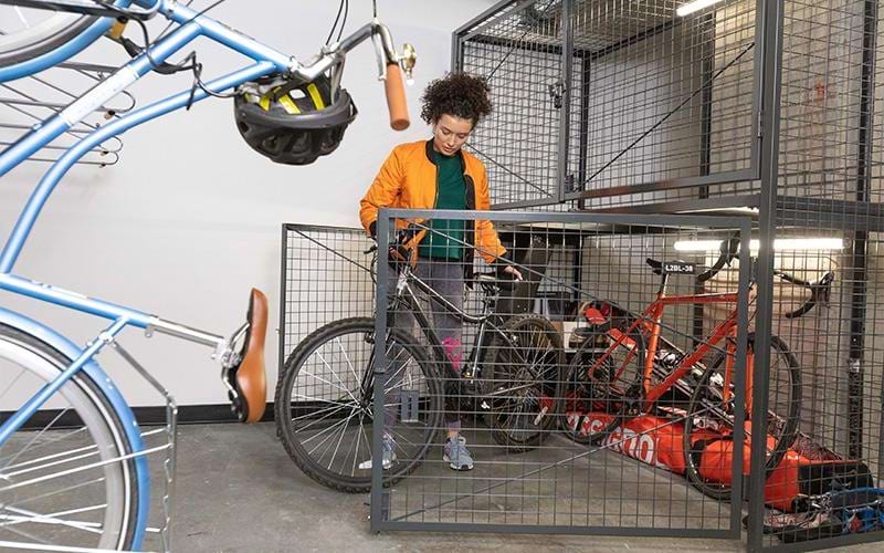 a boy standing next to a bike rack