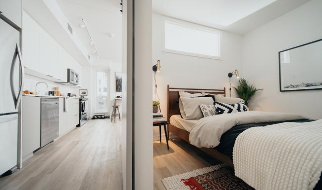 a bedroom with a bed and a refrigerator
